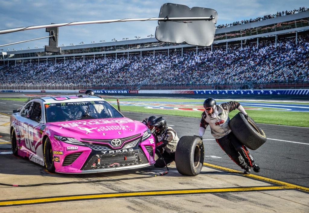 pit crew changes a tire during a race